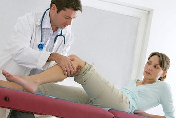 the doctor examines the leg after surgery for varicose veins